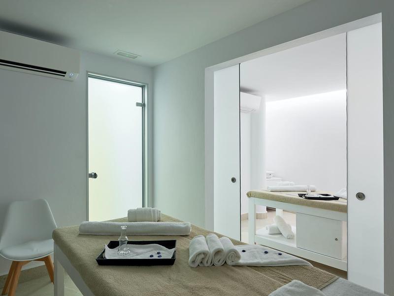 Moderne kamer met massagetafel, handdoeken en aparte badkamer.