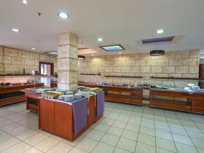 Station de buffet moderne avec comptoirs en bois et large choix dans une pièce lumineuse.