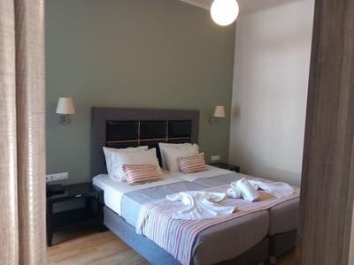 Habitación de hotel acogedora con dos camas unidas, mesas de noche y toallas decorativas.