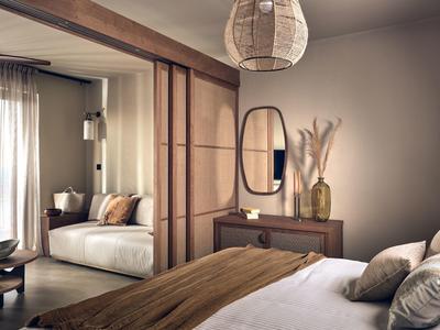 Gemütliches Schlafzimmer mit Holzmöbeln, ovalem Spiegel und weichen Kissen in Erdtönen.