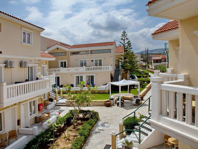 Widok na zadbany dziedziniec hotelowy z alejkami i zielonymi terenami.