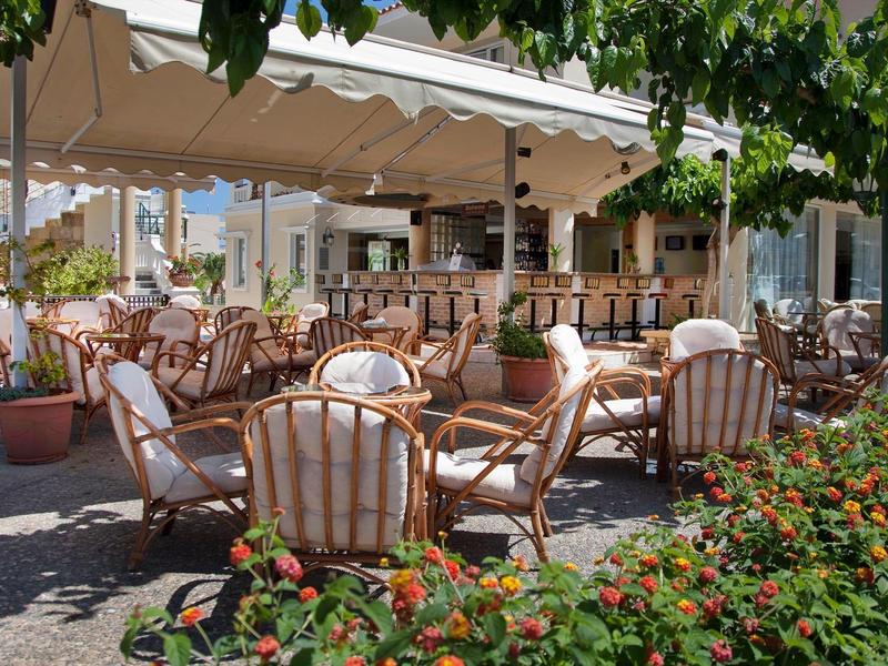 Przytulny taras hotelowy na zewnątrz z meblami ogrodowymi i roślinami pod daszkiem