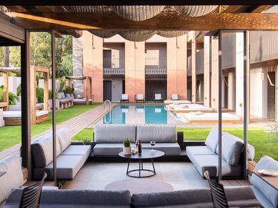 Cortile moderno con piscina e aree salotto confortevoli in un hotel.
