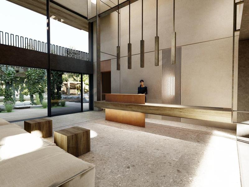 Hall d'hôtel lumineux avec grandes fenêtres, bancs et comptoir d'accueil.