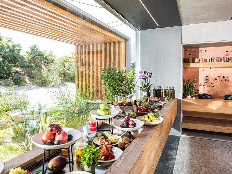 Buffet avec plats variés et vue sur un jardin verdoyant à travers une grande fenêtre