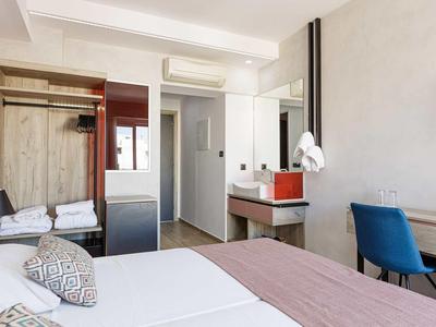 Moderne hotelkamer met twee eenpersoonsbedden, bureau en badkamer.