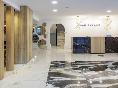 Modern hotel lobby with marble floor and minimalist wood and mirror elements