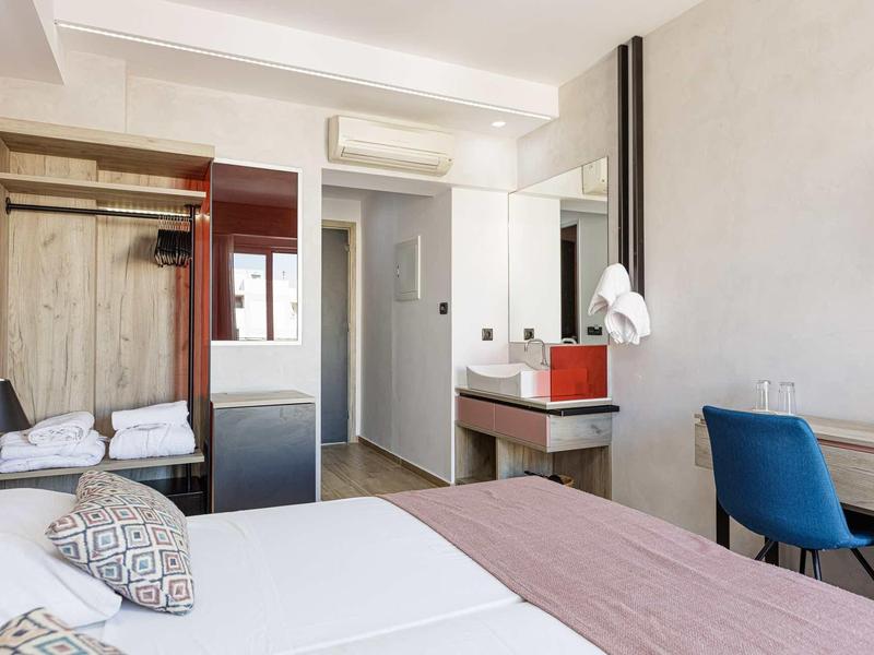 Moderne hotelkamer met twee eenpersoonsbedden, bureau en badkamer.