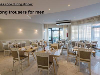 Bright restaurant with modern wooden tables and chairs under soft wall lights.