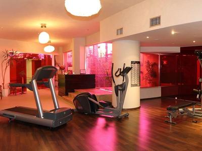 Moderne fitnessruimte met loopband, krachtapparaten en helder ontwerp.