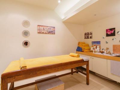 Cozy spa room with massage table and soothing wall decorations.