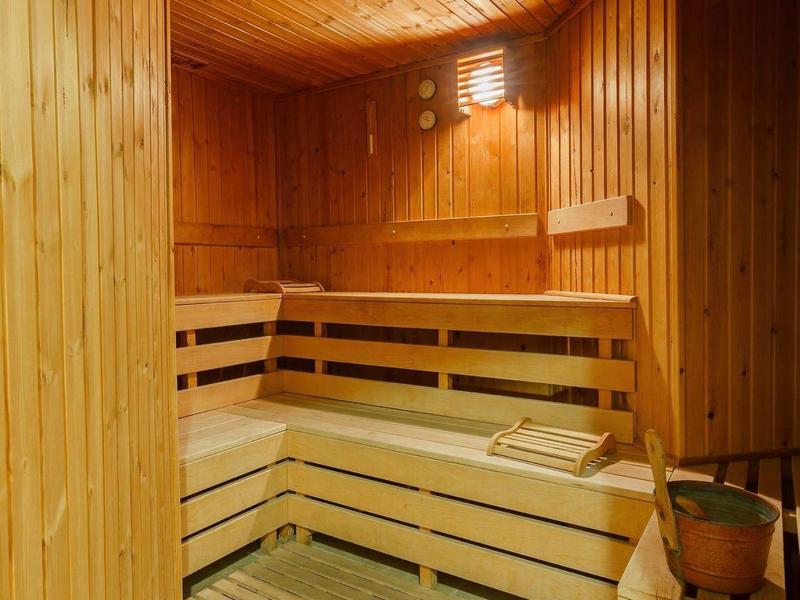 Cozy wooden sauna with tiered benches and a small window for ventilation.