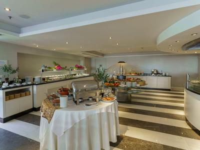 Buffetopstelling in een ruime eetzaal met voedselpresentaties en elegante inrichting.