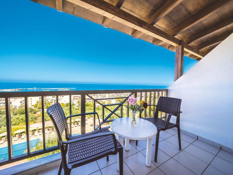 Beleuchteter Hotelpool bei Nacht mit Liegestühlen und Sonnenschirmen unter klarem Himmel.