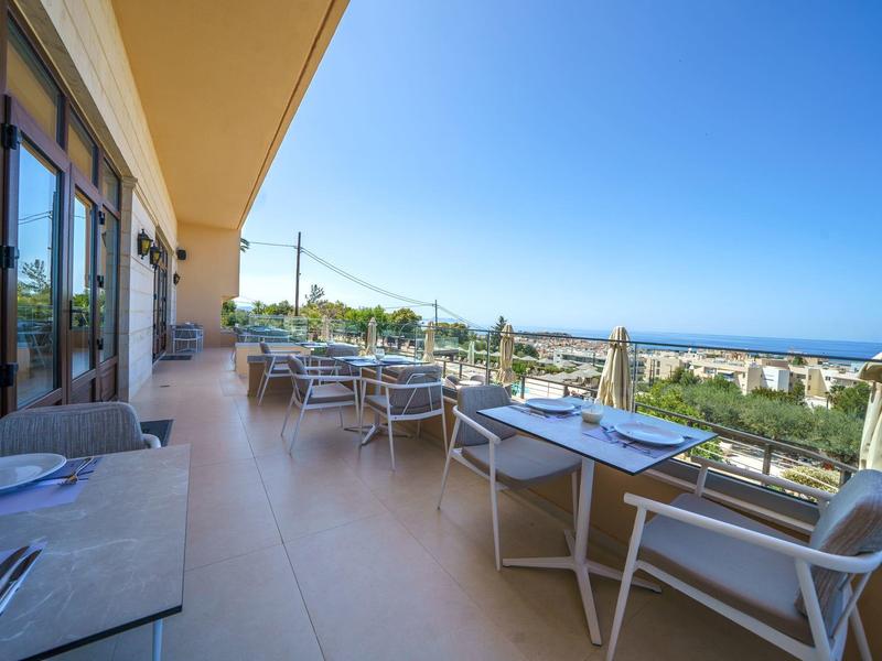 Große Terrassen mit Tischen und Stühlen, Meerblick bei klarem Himmel
