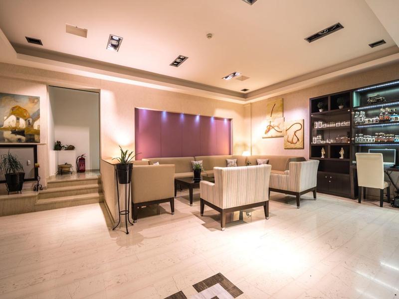 Eleganter Hotel-Loungebereich mit bequemen Sesseln, beleuchteten Regalen und modernem Ambiente.