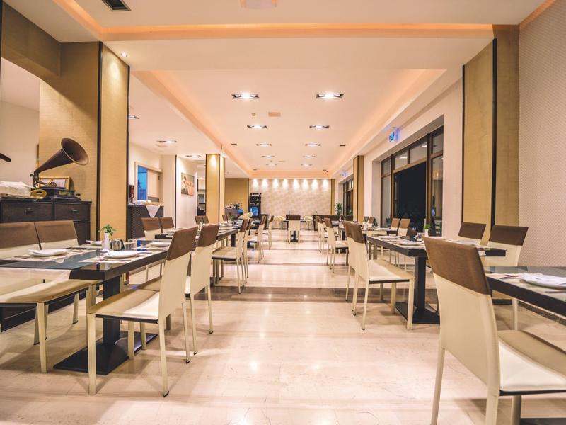 Eleganter, heller Speisesaal mit modernen Möbeln und einem Flügel im Hintergrund.