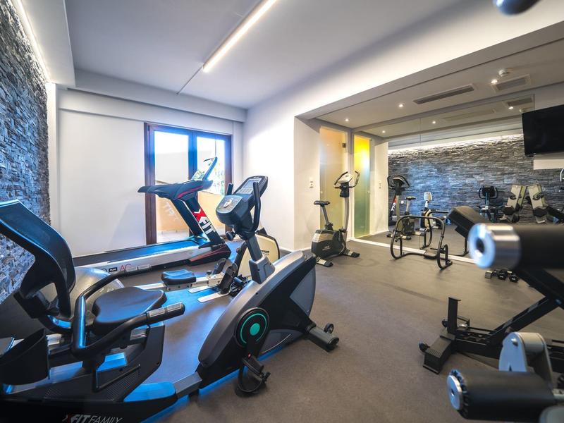 Moderner Fitnessraum mit verschiedenen Sportgeräten in einem Hotel.