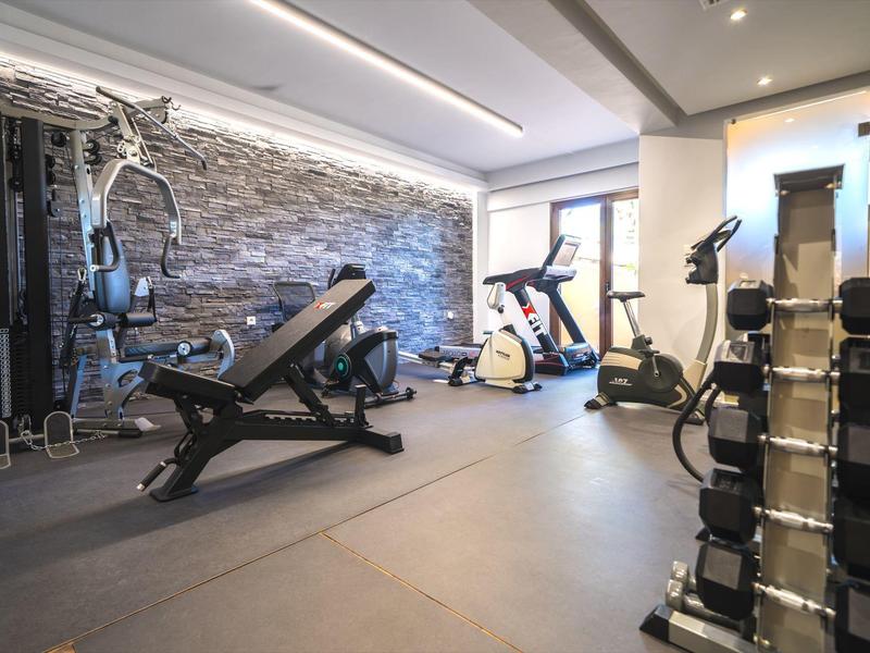 Moderner Fitnessraum mit Geräten und Hanteln in einem hellen, gut beleuchteten Raum.