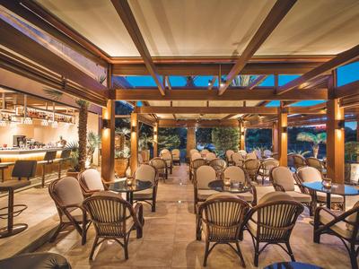 Otwarta przestrzeń stylowej restauracji z wygodnymi krzesłami i barem wieczorem.