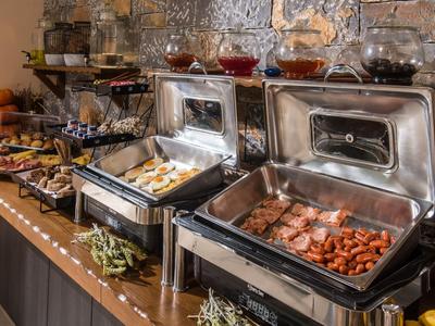 Buffet mit Warmhaltegeräten, belegten Broten, Aufschnitt und Schalen mit Lebensmitteln.