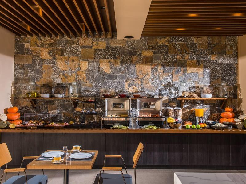 Buffet met diverse ontbijtopties en dranken in een moderne eetruimte.