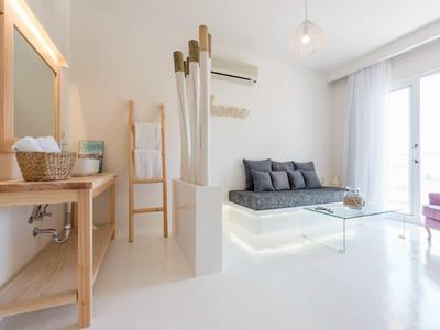 Moderně zařízený obývací pokoj se šedou pohovkou, skleněným stolkem a světlými zdmi