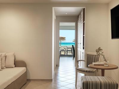 Widok z nowoczesnego salonu z sofą przez korytarz na taras z widokiem na morze.