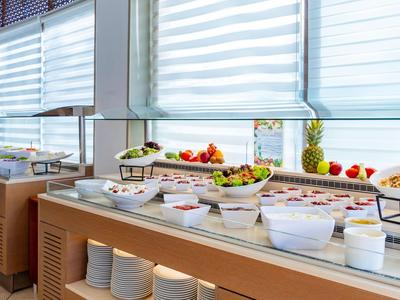 Bufet z świeżymi owocami i sałatkami w jasnej restauracji hotelowej