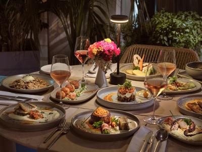 Ein gedeckter Tisch mit verschiedenen Speisen und Getränken in einem gemütlichen Restaurantumfeld.
