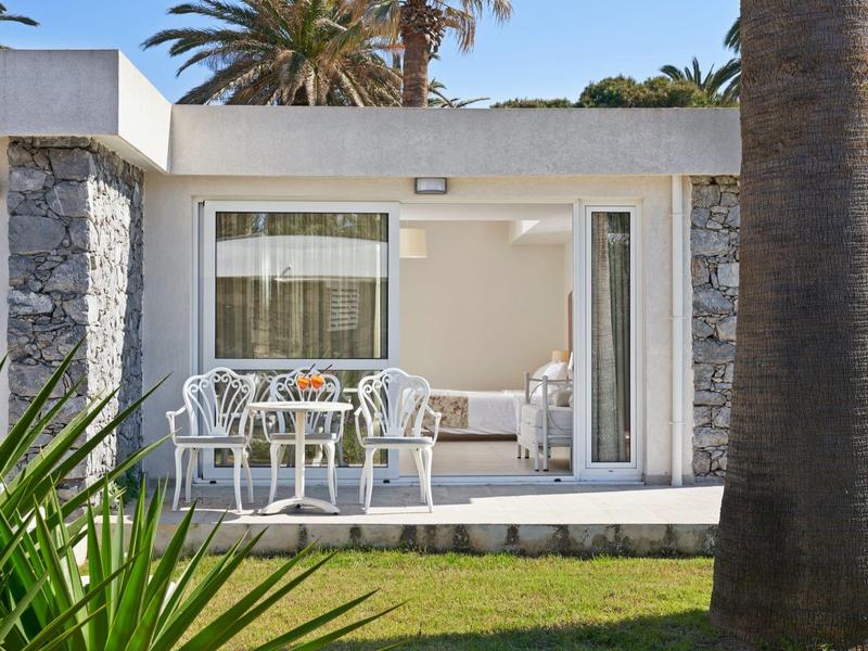 Nowoczesny balkon hotelowy z stołem, krzesłami i widokiem na ogród palmowy