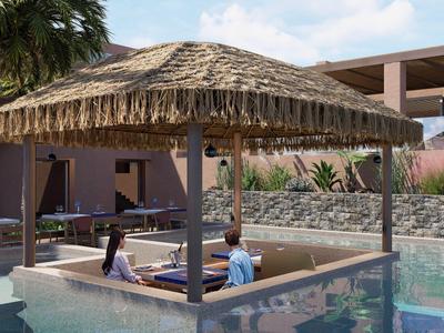 Dos personas sentadas en un área cubierta en la piscina de un hotel.