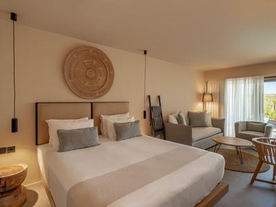 Modernes Hotelzimmer mit Doppelbett, Holzdetails und Balkon mit Aussicht.