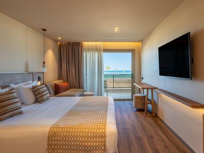 Modern eingerichtetes Hotelzimmer mit Doppelbett, Balkon und Meerblick.