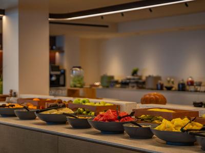 Buffet mit verschiedenen Obst- und Salatschalen in einem Hotelrestaurant.