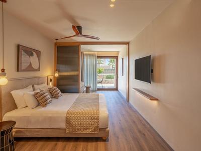 Modernes Hotelzimmer mit Doppelbett, Wand-TV und Zugang zu Balkon mit Meerblick.