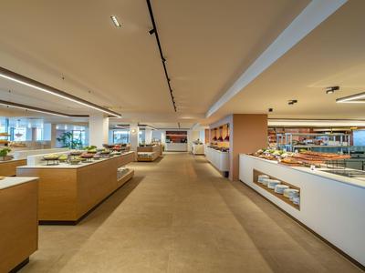 Hell beleuchteter Buffetbereich mit modernen Holz- und weißen Elementen in einem Hotel.