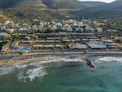 Strandhotel mit umfangreichen Pools, direktem Zugang zum Meer und umliegenden Bergen.