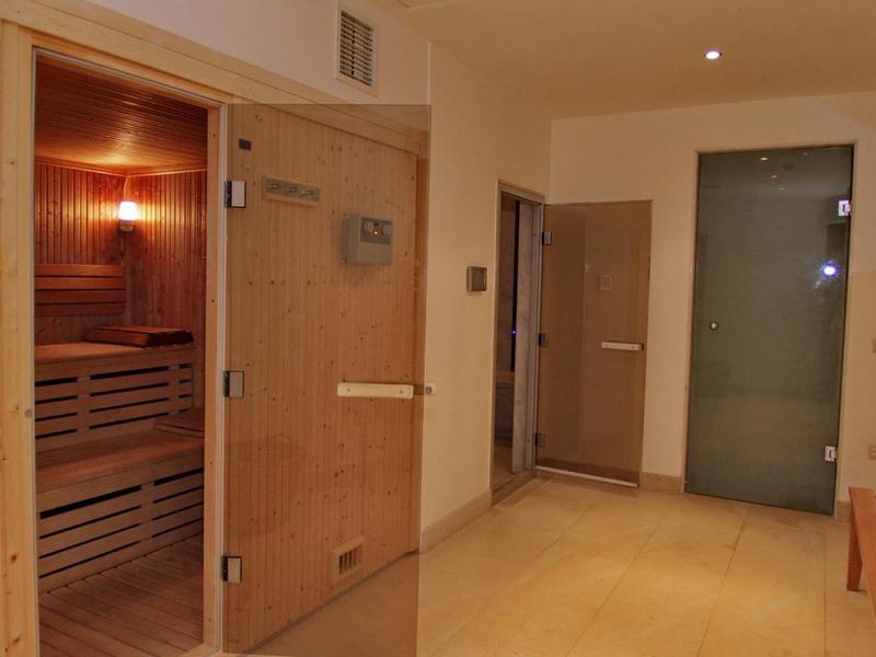 Sauna intérieure confortable avec intérieur en bois et porte en verre dans un spa.