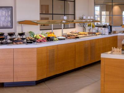 Grand buffet de petit-déjeuner avec éclairage chaleureux et variété de plats dans un hôtel.