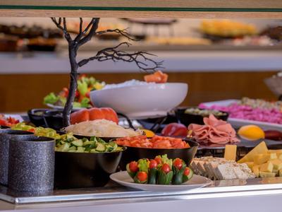 Buffet mit einer Vielzahl von frischen Lebensmitteln und einem minimalistischen Baum als Dekoration.