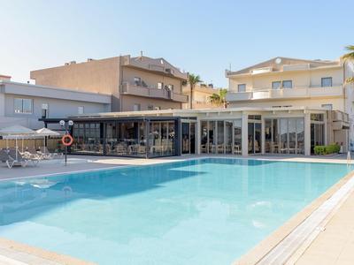 Moderner Hotelpool mit Liegestühlen und Sonnenschirmen bei klarem Himmel.