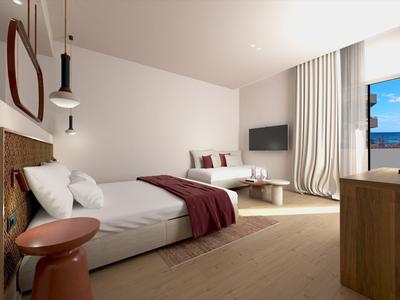 Moderní hotelový pokoj s postelí, pohovkou, televizí a velkými okny s výhledem ven.