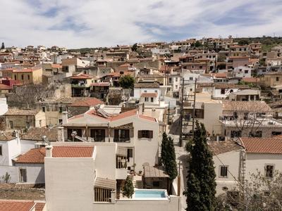 Vue d'un quartier résidentiel densément construit avec des maisons blanches et des toits rouges sous un ciel nuageux.