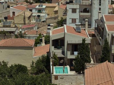 Vue sur des maisons méditerranéennes aux toits rouges avec une petite piscine dans la cour.