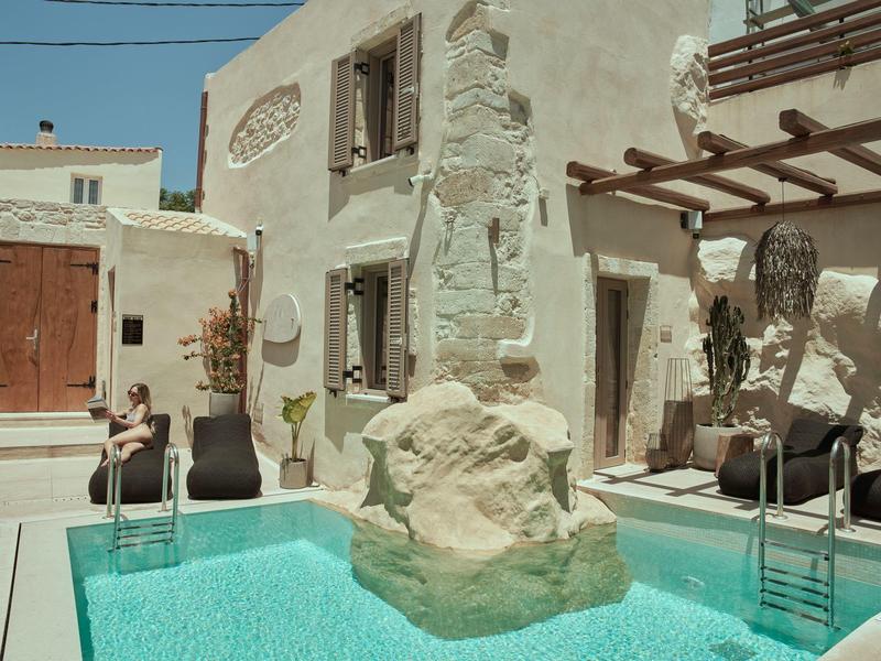 Cour intérieure avec piscine et espaces de détente dans un hôtel à l'architecture traditionnelle.