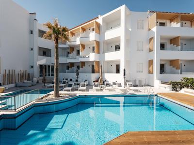 Nowoczesny kompleks hotelowy z basenem, leżakami i palmami pod czystym niebem.