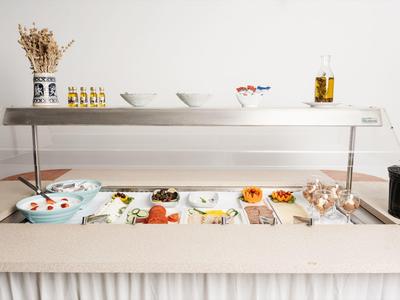 Bufet samoobsługowy z różnymi zimnymi przystawkami i sałatkami w miseczkach i na talerzach