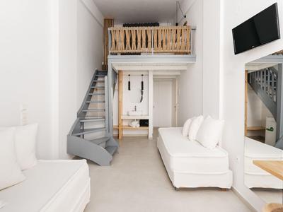 Jasny salon z białymi sofami, spiralnymi schodami i drewnianym antresolą w nowoczesnym pomieszczeniu.