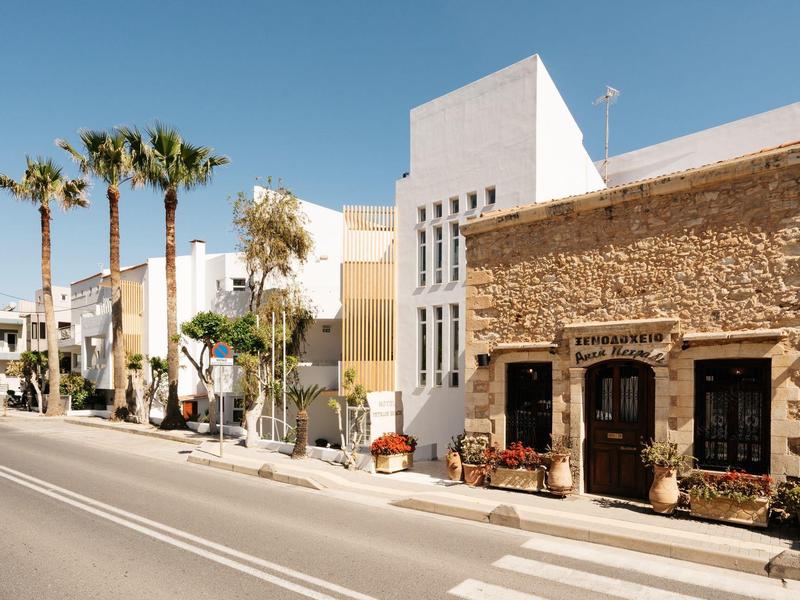 Scena uliczna z nowoczesnymi i tradycyjnymi budynkami pod niebieskim niebem i palmami